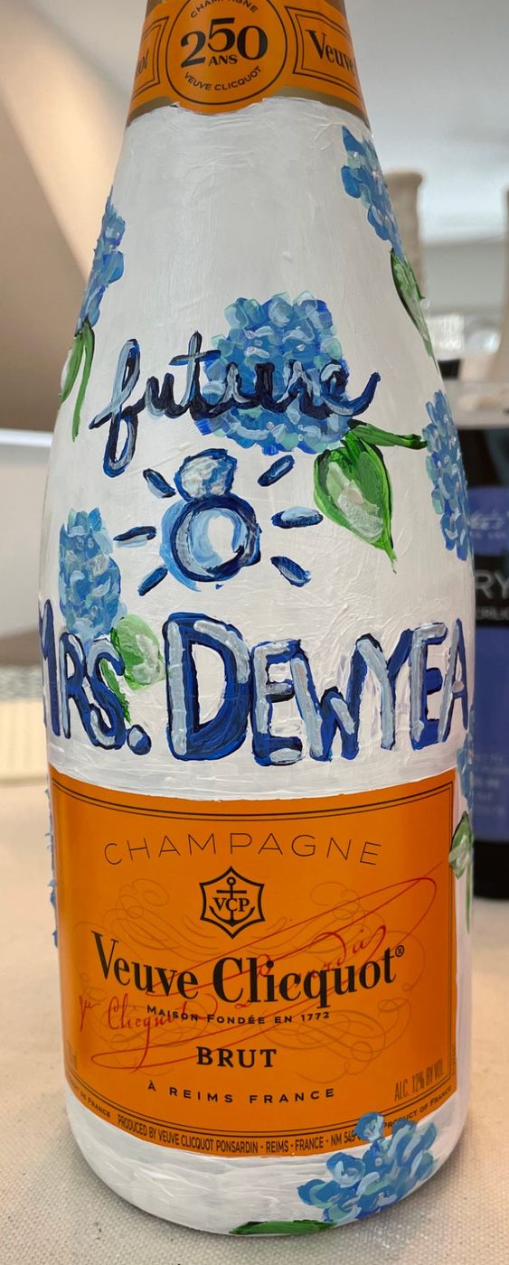 Hand-painted champagne bottle with blue hydrangeas and a ring, reading future Mrs. Dewyea